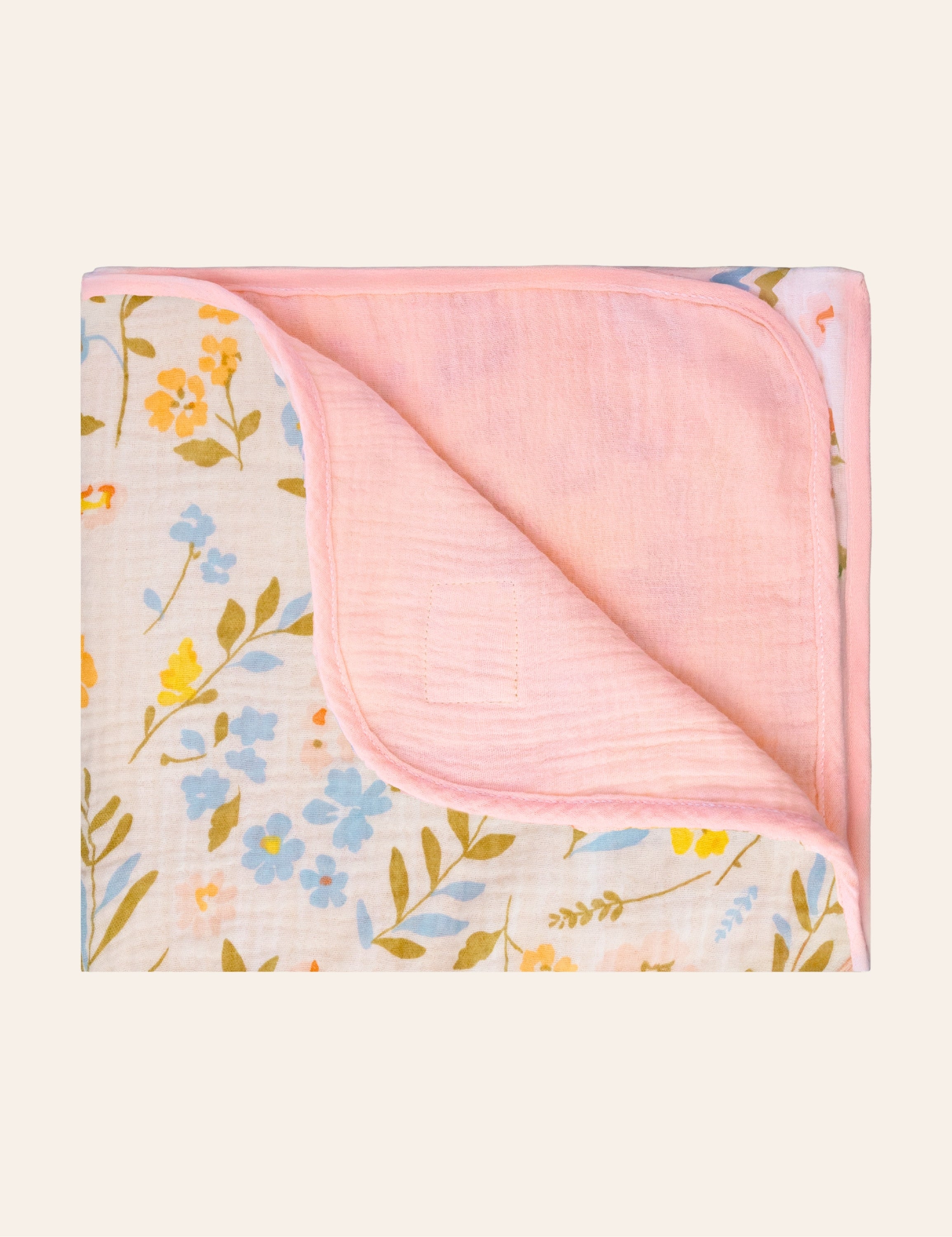 Two sided uslin blanket with one side solid pink and one side floral-patterned.