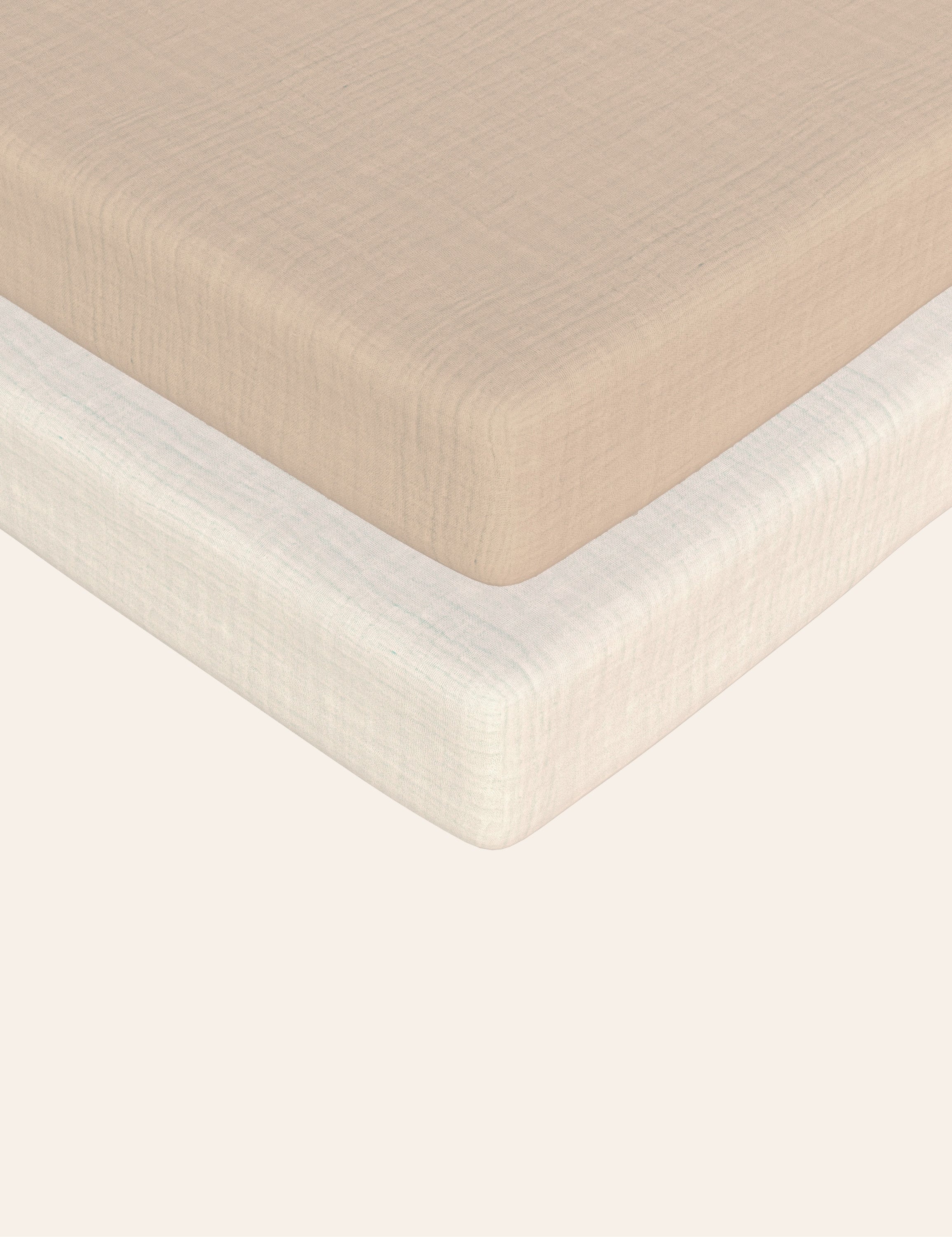 Close-up of solid beige and solid white textured muslin bassinet sheets