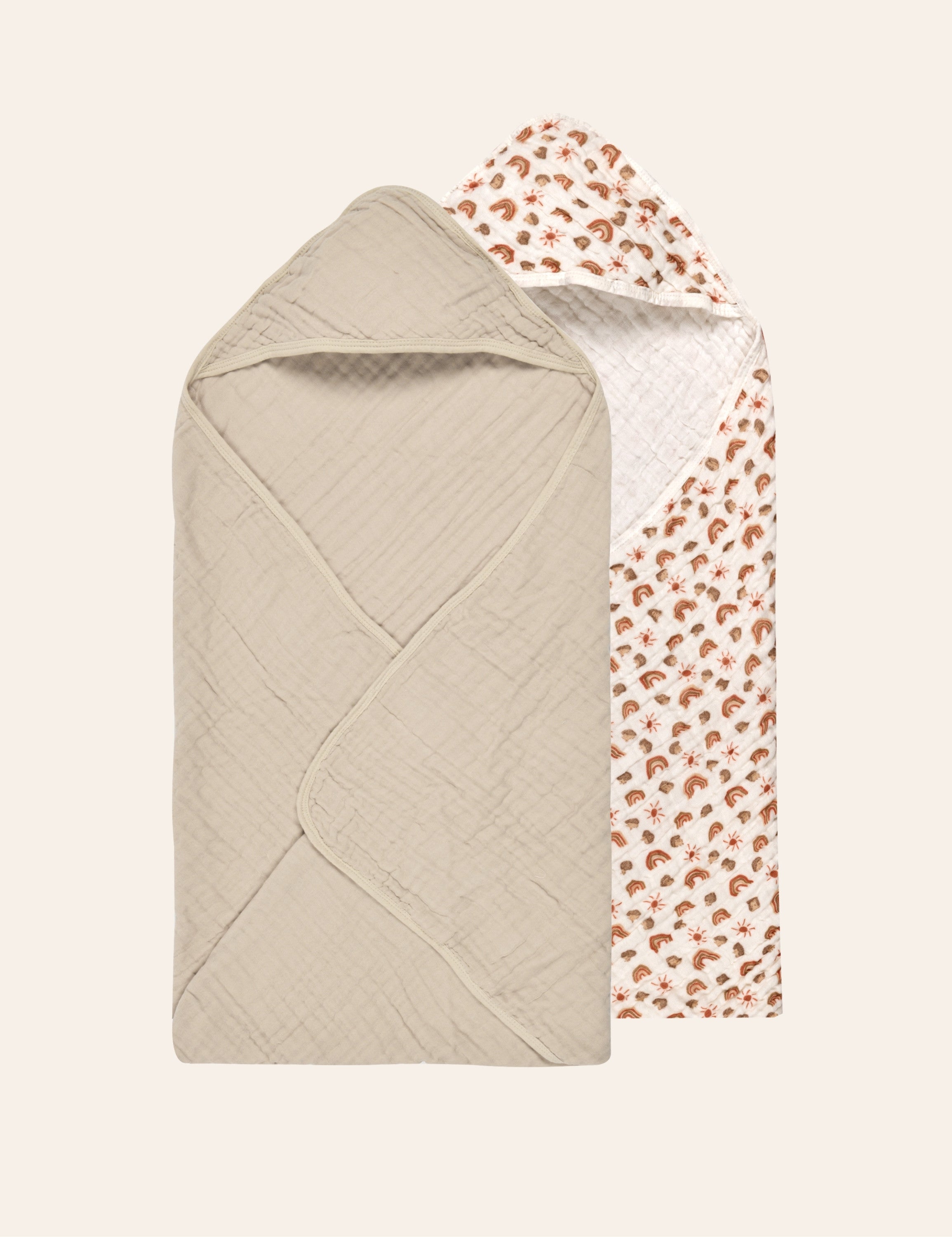 Solid beige and rainbow print baby hooded towels on a beige background