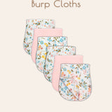 Set of six ultra-soft muslin burp cloths with floral patterns and solid pink colored patterns displayed together