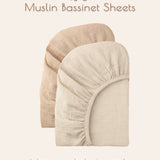 Two solid beige colored muslin bassinet sheets on a light beige background with text about wrapping babies in gentle muslin magic.