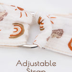 Rainbow patterned beige adjustable strap of a muslin nursing cover