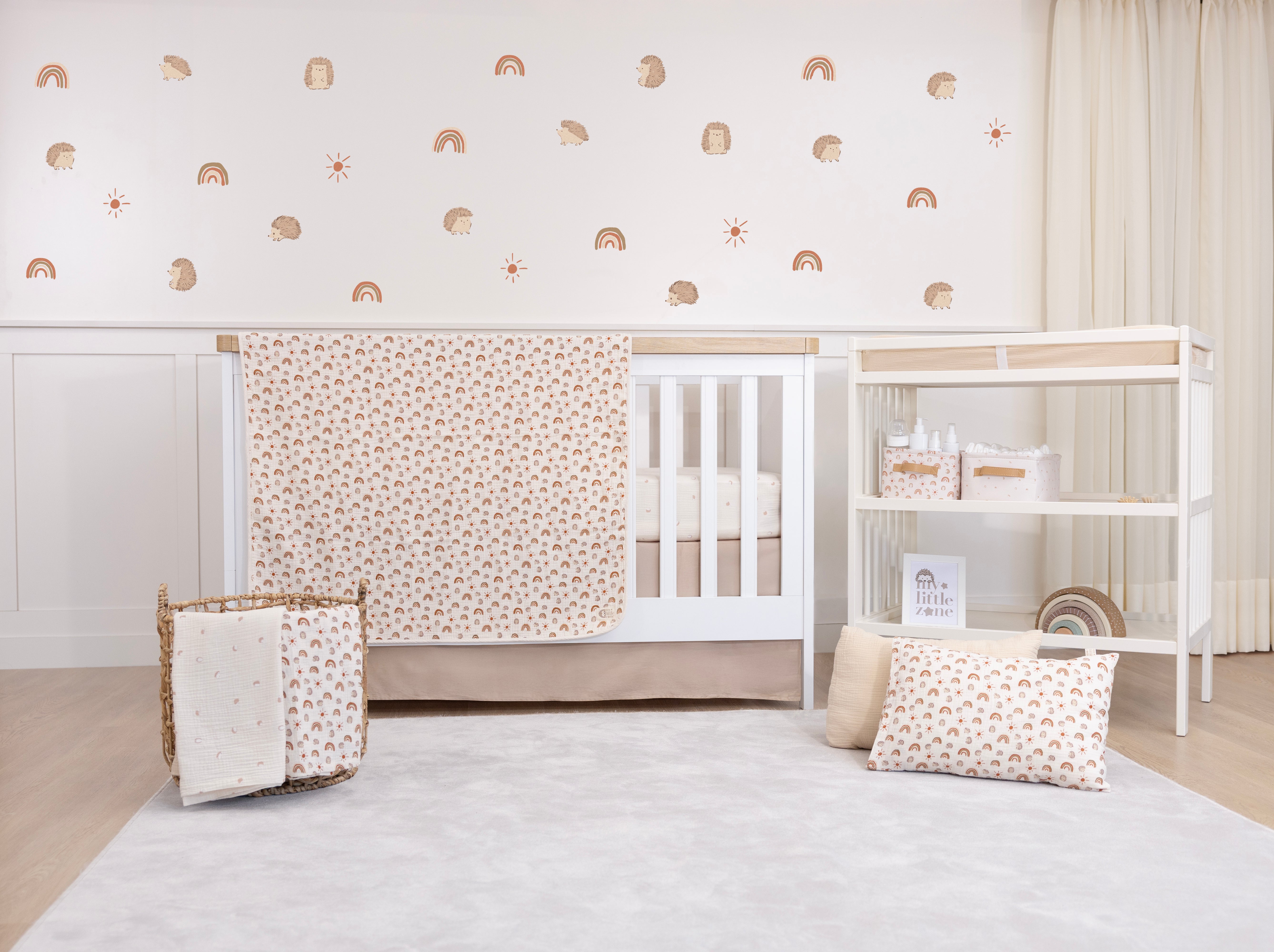 Nursery room with white crib, decorative wall, and baby items.